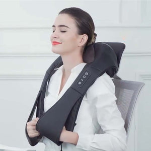 Mujer aliviando tensión cervical con masajeador shiatsu mientras trabaja en su escritorio