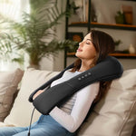 Mujer usando masajeador shiatsu en el cuello, con expresión de relajación profunda mientras descansa en su sofá