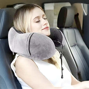 Mujer descansando plácidamente con almohada viscoelástica Ergo Travel Pillow en asiento de autobús, expresión de alivio cervical